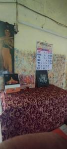 a room with a bed with a calendar on the wall at Viswanatham Guest House in Varanasi