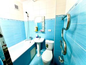 a blue bathroom with a toilet and a sink at Квартиры посуточно Талдыкорган in Taldykorgan