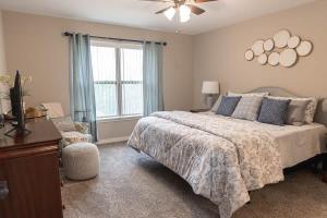 a bedroom with a bed and a dresser and a window at Brand New 2 Bedroom with Office in Loves Park