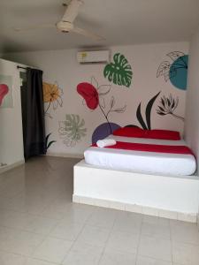 a bedroom with a bed with flowers on the wall at Hostal Finca San Martín De Loba in Los Naranjos