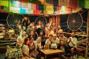 un gruppo di persone che posano per una foto su un palco di Planet Nomad Hostel a Kathmandu