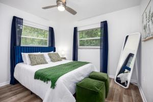 a bedroom with a bed and a mirror and a chair at Vibrant 4bd with Games & Backyard - 5 Mins to UF in West Hills