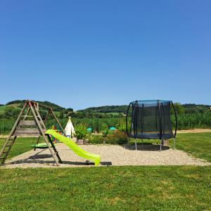 a playground with a slide and a swing set at Le Domaine Vesque. Le LOFT in Saint-Pierre-de-Clairac