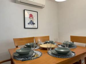 un tavolo in legno con piatti e ciotole sopra di Neruka House a Torremolinos