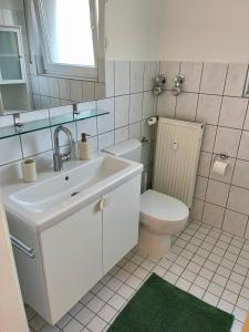 a white bathroom with a sink and a toilet at Groß, aber gemütlich - citynah in Unna