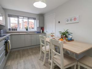 a kitchen with a wooden table and chairs in a kitchen at Elwell Cottage in Beverley +9 photos
