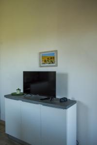 a table with a flat screen tv on a white wall at La casa di campagna in Manciano