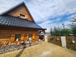 a wooden house with a fence in front of it at Chalupka u macka in Párnica