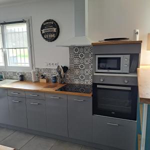 a kitchen with a microwave and a stove at Le Domaine Vesque. Le LOFT in Saint-Pierre-de-Clairac