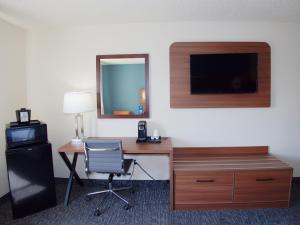 a room with a desk with a computer and a chair at Ramada by Wyndham Coeur d'Alene in Coeur d'Alene