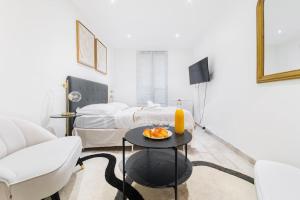 un soggiorno con tavolo e 2 letti di Studio Confortable proche métro - Saint mandé a Saint-Mandé