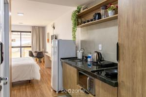 a kitchen with a refrigerator and a bed in a room at Studio perfeito em Poços de Caldas MG PGO310 in Poços de Caldas