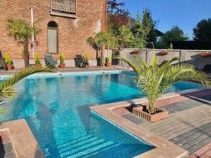 a swimming pool with palm trees next to a brick building at Hotel Like Mari in P'ichvnari +26 photos