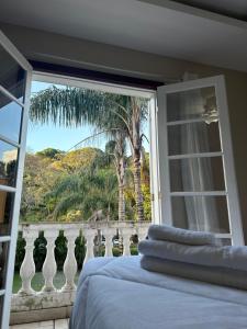 a bedroom with a window with a view of a palm tree at Pousada Crystal Palace in Petrópolis