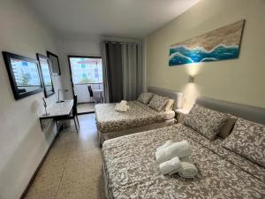 un salon avec deux lits et un bureau dans une chambre dans l'établissement Sunny Garden&Playa Apartment - Playa Del Inglés, à Playa del Ingles 46 autres photos