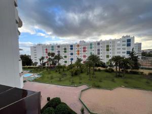 un grand bâtiment avec un parc devant dans l'établissement Sunny Garden&Playa Apartment - Playa Del Inglés, à Playa del Ingles