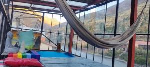 una habitación con hamaca en una habitación con ventanas en Aguaymanto pisac hostel, en Písac 17 fotos más