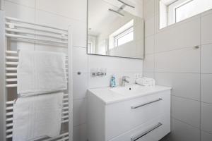 Un baño blanco con lavabo y espejo. en Sandkorn-Büsum, en Büsum 45 fotos más