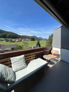a balcony with a bed and a table and a view at PanoramaVista in Hof bei Salzburg