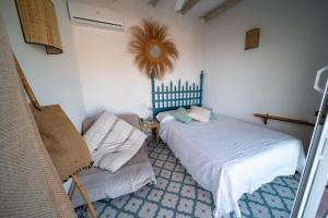 ein Schlafzimmer mit 2 Betten und einem Stuhl darin in der Unterkunft Los Espejos de Frigiliana in Frigiliana + 31 Fotos