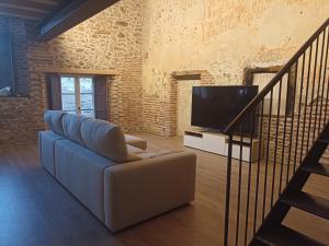 a living room with a couch and a television at El Esquileo in Buitrago del Lozoya
