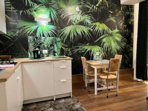 a kitchen with a table and chairs with a tropical wallpaper at Jungle Fever in Turin