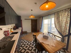 a kitchen with a wooden table in a kitchen with a tableablish at İncirci Stone House, Sazlı Köyü in Ayvacık