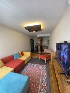 a living room with a couch and a flat screen tv at İncirci Stone House, Sazlı Köyü in Ayvacık