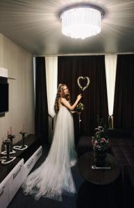 バルナウルにあるHotel Prestigeの心を持つ結婚式の服装の女