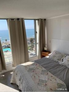 a bedroom with a bed and a view of the ocean at Departamento vista al mar in Coquimbo