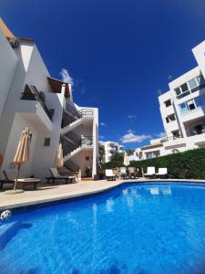 a villa with a swimming pool in front of a building at Rotonda Apartaments in Felanitx