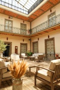 un patio con sillas, mesas y tragaluz en CASA SAUTO11 Mexican architecture and design suite, en Ciudad de México