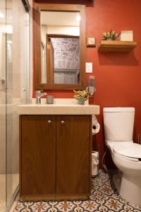 Un baño con lavabo, inodoro y espejo. en CASA SAUTO11 Mexican architecture and design suite, en Ciudad de México 25 fotos más