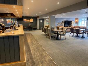 a restaurant with a bar and tables and chairs at Sunrise Luxurious holiday home in Cubert