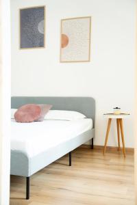 a bed in a white room with two pictures on the wall at Casa Lina in Trieste +10 photos