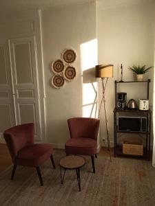a living room with two chairs and a table at Appartement sur la route touristique du champagne in Sézanne