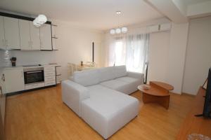 a living room with a white couch and a table at Motra Apartment in Metogjashta