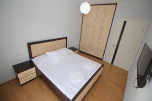 a small bedroom with a bed and a television at Motra Apartment in Metogjashta