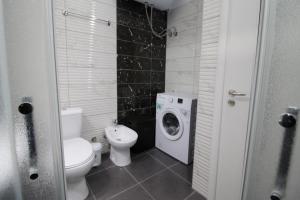 a bathroom with a toilet and a washing machine at Motra Apartment in Metogjashta +17 photos