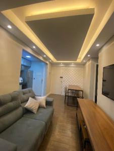 a living room with a couch and a flat screen tv at Apartamento Premium Taubaté in Taubaté +2 photos