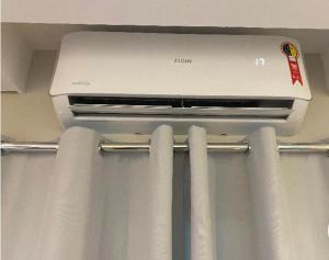 a laptop computer sitting on top of a curtain at Apartamento Premium Taubaté in Taubaté
