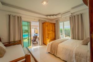 a bedroom with a bed and a view of the ocean at A Casa da Ponte, Casa em condominio para Familias, Festas e Eventos in Bertioga +69 photos