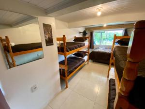 a room with several bunk beds in a room at Pousada Jardim da Lagoa in Garopaba +48 photos