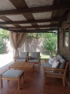 a patio with couches and tables under a pergola at El Vivero in Chiclana de la Frontera