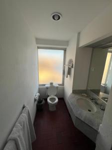 a bathroom with a toilet and a sink and a window at Islas del Sol in Mazatlán +22 photos