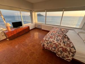 a bedroom with a bed and a desk with a computer at Islas del Sol in Mazatlán