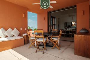 une salle à manger avec une table, des chaises et un canapé dans l'établissement 4 BR Penthouse - Breathtaking Views - Private Pool, à Zihuatanejo