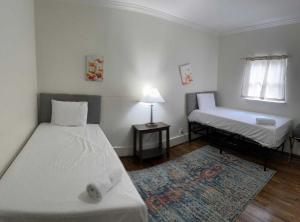 a bedroom with two beds and a window and a rug at Norwood Nugget-Tee Off at Top Golf, Historic Charm in Birmingham