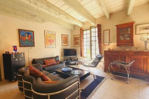 a living room with a couch and a tv at Maison de Village en Camargue Parking Clim Wifi - ROSSIconciergerie - Linge inclus in Saint-Laurent-dʼAigouze