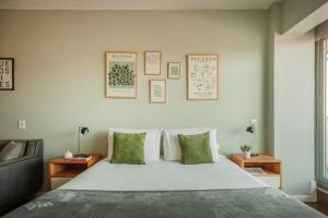 een slaapkamer met een groot wit bed met groene kussens bij High End Cozy Apt at CENTRAL RECOLETA -Amazing View- powered by Argenhost 12H in Buenos Aires +48 foto's